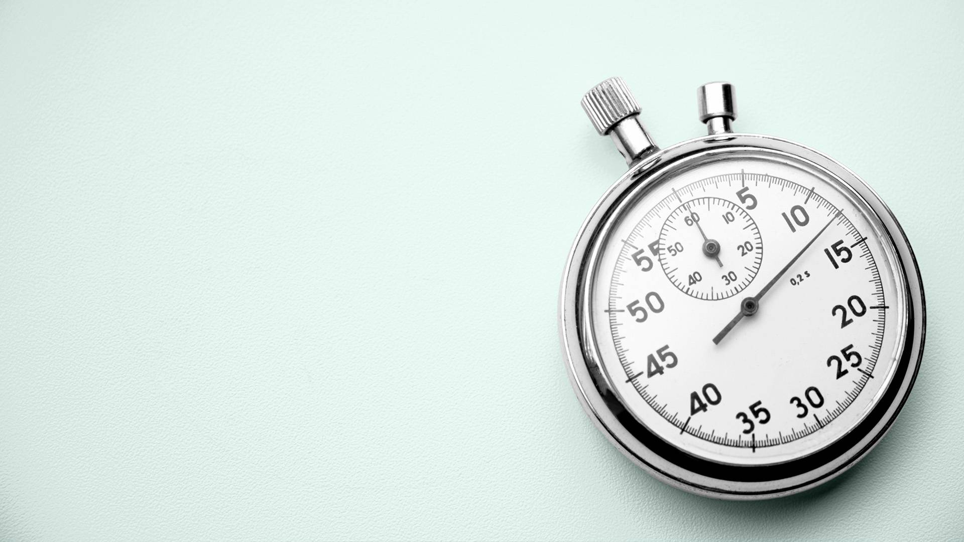 A traditional stopwatch on a plain background.