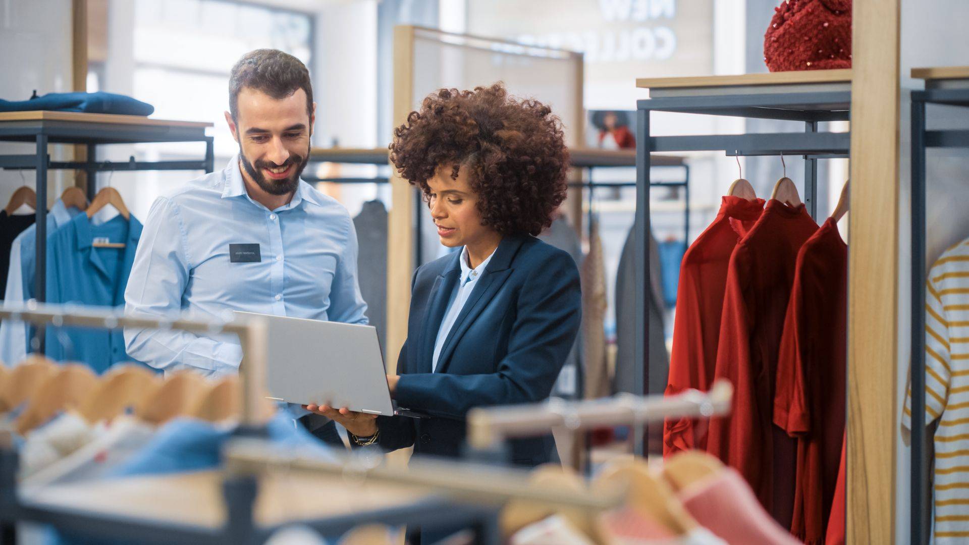 Retail Two retail professionals looking at a laptop screen in a clothing store.
